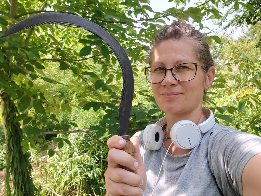 Kobieta z sierpem w ogrodzie